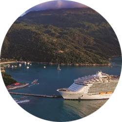 Long range view of a cruise ship docked at a tropical resort island.