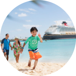 Family playing on the beach near a docked cruise ship.