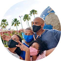 Family of 4 taking a selfie at the entrance to Universal Orlando.