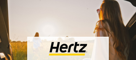 A Hertz logo over a woman looking at a field from her car.